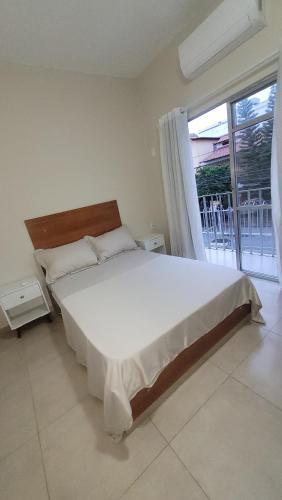 sypialnia z łóżkiem i dużym oknem w obiekcie Apto 3qts na Praia do Forte em Cabo Frio w mieście Cabo Frio