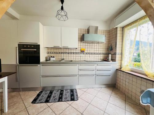 a kitchen with white cabinets and a sink at Appartamento Margherita in Transacqua