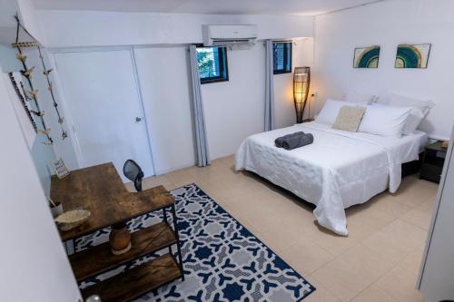 Un dormitorio blanco con una cama y una mesa. en The Central Residence Suva, en Suva