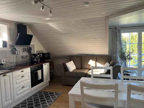 Una cocina y una sala de estar con un sofá y una mesa. en Solhem Terrassen, en Arvika