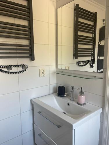 Un baño blanco con lavabo y espejo. en Solhem Terrassen, en Arvika