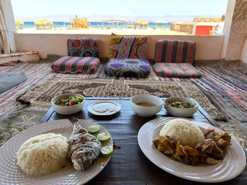 a table with plates of food on it with a view of the ocean at Mountain camp in Wāsiţ
