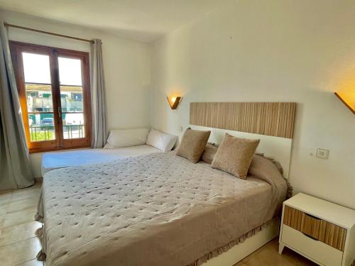 a bedroom with a large bed and a window at SA CALETA - Apartamento con piscina y junto a la playa in Cala en Blanes