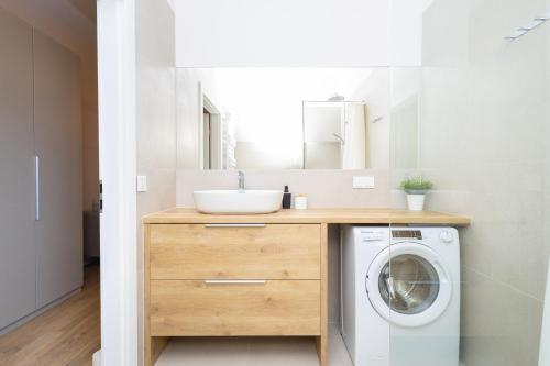 a bathroom with a sink and a washing machine at Central Lux Apartment - Heart of the Old Town Check In 24h in Wrocław