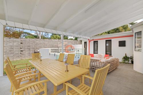a patio with a wooden table and chairs at Lush Kuluin Escape Private Pool & Short Drive to Mooloolaba Beach in Buderim