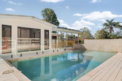 a swimming pool in the backyard of a house at Lush Kuluin Escape Private Pool & Short Drive to Mooloolaba Beach in Buderim