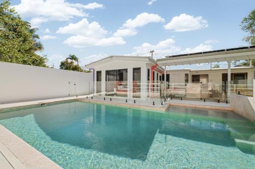 a swimming pool in front of a house at Lush Kuluin Escape Private Pool & Short Drive to Mooloolaba Beach in Buderim