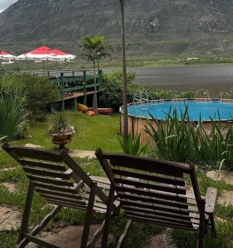 una panchina di legno seduta accanto alla piscina di Quintal da Prainha - Lapinha da Serra a Santana do Riacho