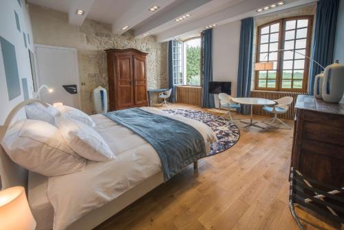 a bedroom with a large bed and a television at Chateau Prieure Marquet in Saint-Martin-du-Bois