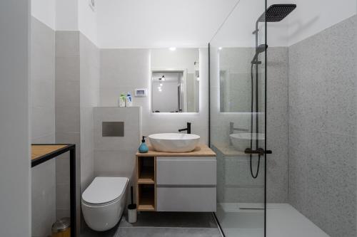 Un baño con lavabo, inodoro y ducha. en Vuls Apartments, en Sibiu