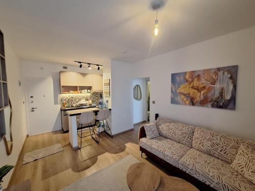 a living room with a couch and a kitchen at Tatu Nest in Tatu City