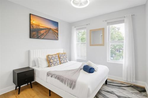 a white bedroom with a bed and two windows at Stylish 5BR DC Retreat Backyard Free Parking in Washington, D.C.