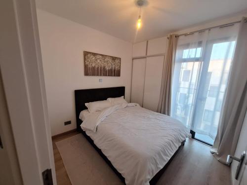 a white bed in a room with a large window at Tatu Nest in Tatu City