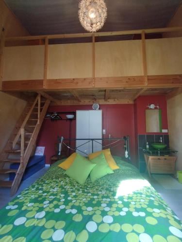 a bedroom with a bed with green and yellow pillows at chateau d'eau logement insolite in Tournemire