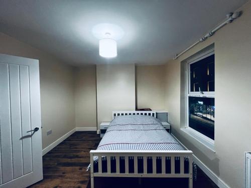 a small bedroom with a bed and a window at The Central Hub Luton A in Luton