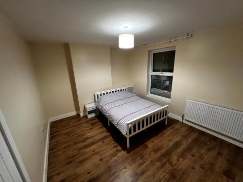 a small bedroom with a bed and a window at The Central Hub Luton A in Luton