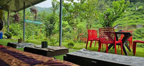 a group of chairs and tables in a yard at Green River Camp in Rishīkesh