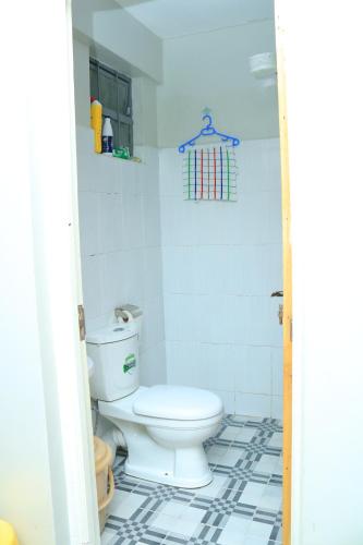 a bathroom with a toilet and a tiled floor at SpeedwayHaven, 2Mins TO SpurMall & Ashaki Resort 1750 or 1850 or 2000kes in Ruiru