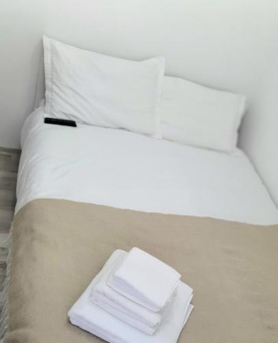 a white bed with a pile of towels on it at Relax Apartament Bicaz in Bicaz