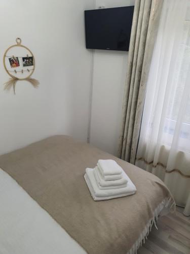 a bed with two white towels on it in a room at Relax Apartament Bicaz in Bicaz