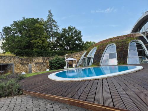 a swimming pool on a wooden deck next to a building at Tinyhaus Wolkenlos Familie Hamdorf in Bad Sulza