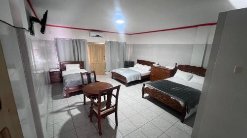 a hotel room with two beds and a table at Recidencial nube69 in Santa Cruz de la Sierra