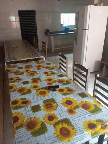 a table with sunflowers on it in a kitchen at Hospedagem e Pousada Cachoeira Paulista in Cachoeira Paulista