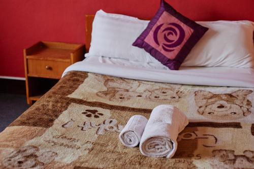 BaudhatinchuleにあるBodhi houseの毛布と2枚の丸めたタオルが敷かれたベッド