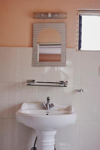 a bathroom with a white sink and a mirror at Bodhi house in Baudhatinchule