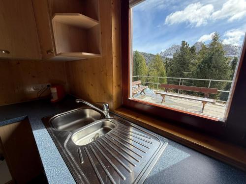 a kitchen with a sink and a window with a view at Berghotel Schlemmer Appartements in Plancios