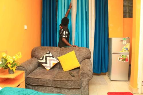 a person is standing on top of a couch at SpeedwayHaven, 2Mins TO SpurMall & Ashaki Resort 1750 or 1850 or 2000kes in Ruiru