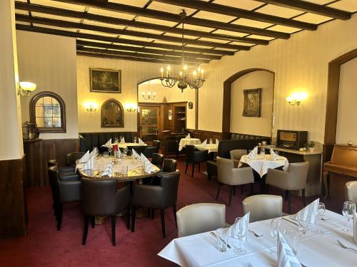 a restaurant with tables and chairs in a room at Nostalgie Altstadthotel Kornpforte in Koblenz