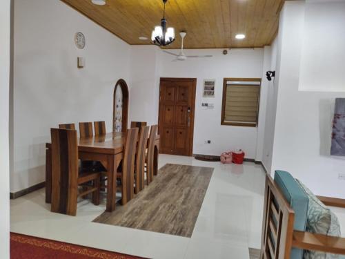 a dining room with a wooden table and chairs at Scenic Lanka Luxury Rooms in Dehiwala