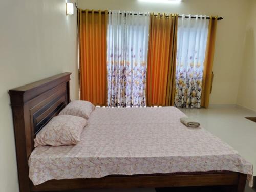 a bedroom with a bed with a wooden headboard and curtains at Scenic Lanka Luxury Rooms in Dehiwala
