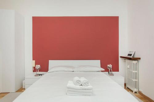 1 dormitorio con 1 cama blanca y 2 toallas en Monti 29 - Corso Sempione Milano, en Milán