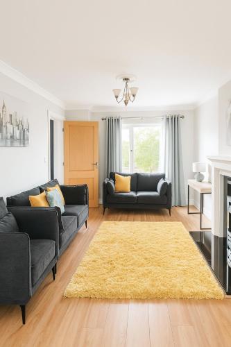 a living room with two couches and a yellow rug at 3 Bed Spacious House in Golf Links Road 