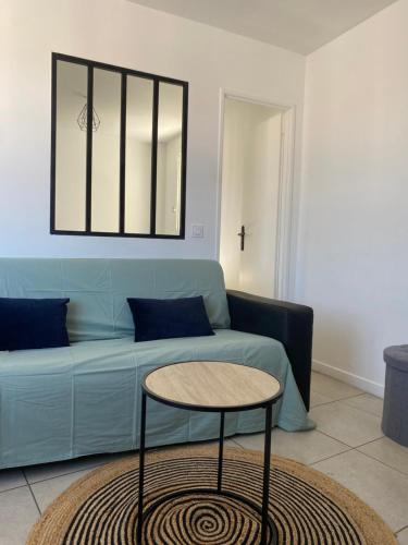 a living room with a blue couch and a table at Montpellier - Corum - Louis Blanc in Montpellier