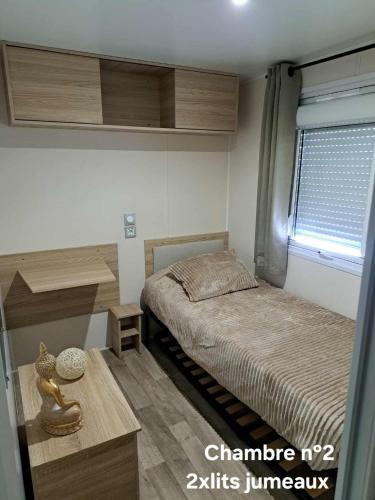 a small bedroom with a bed and a window at Mobilhome Montourey 4 étoiles 3 chambres 2 salles de bain in Fréjus