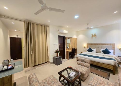 a bedroom with a bed and a living room at HOTEL - VV!NN - Hotel ! Varanasi - Providing Air conditioned & Well Decorated Rooms with Free Wi-Fi - Parking & Restaurant With Lyft Facilities - Best hotel in Varanasi in Rāmnagar