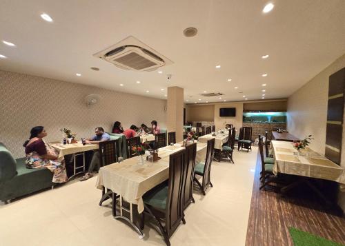 a dining room with people sitting at tables at HOTEL - VISHWANATH ! - ! Varanasi - Providing Air conditioned & Well Decorated Rooms with Free Wi-Fi - & Restaurant With LIft Facilities - Best hotel in Varanasi in Rāmnagar