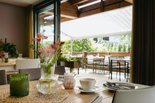 una mesa con un jarrón de flores encima en Hotel Villa Lago, en Bad Wiessee