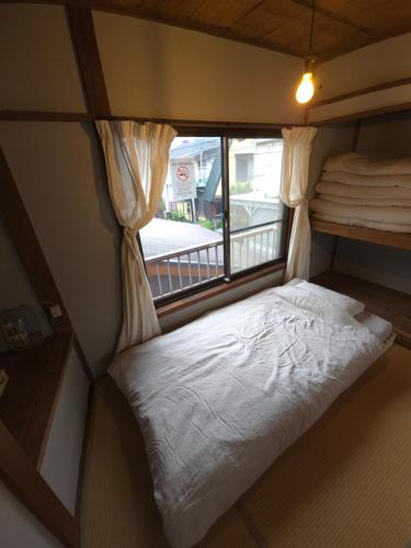 Postel nebo postele na pokoji v ubytování 江ノ電の線路沿いにある宿【film koshigoe】