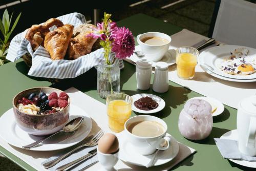 a table with breakfast foods and coffee on it at Hotel Villa Lago in Bad Wiessee