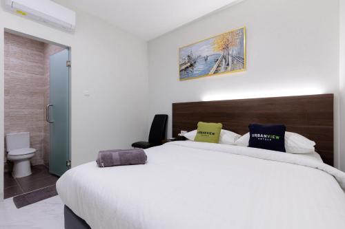 Un dormitorio con una gran cama blanca con dos almohadas. en Urbanview Syariah Hotel Senen Jakarta, en Yakarta