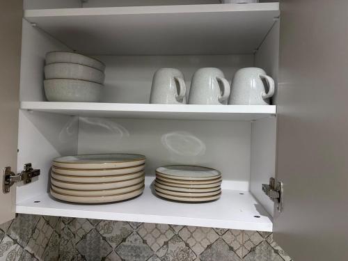 een plank met borden en kommen in een kast bij Cloud9 suites - Westlands Road in Nairobi