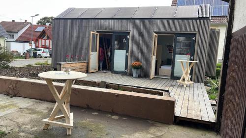 a small house with a wooden deck with a table at XCUBE Tinyhouse in Bad Dürrheim