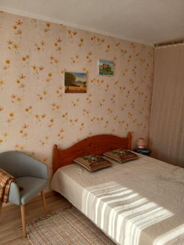 um quarto com uma cama e uma cadeira em Уютный уголок em Narva