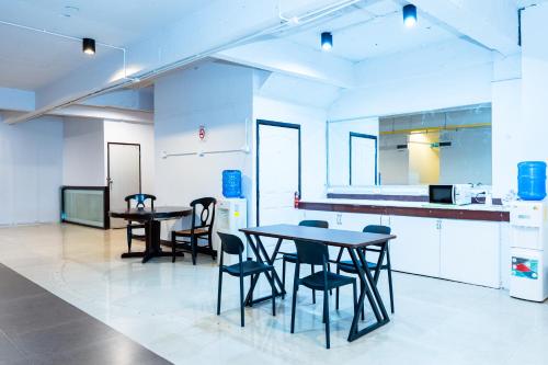 a room with two tables and chairs in a kitchen at XX The Hidden khaosen เดอะ ฮิดเด้น ตรอกข้าวสาร in Bangkok