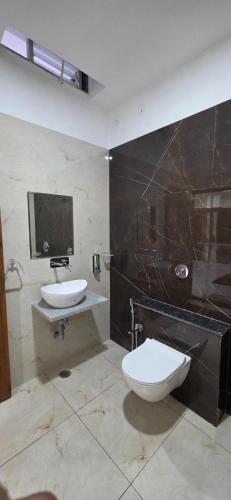 a bathroom with a toilet and a sink at Starlight Restro and Hotel in Hoshangābād