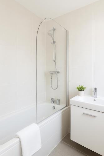 a white bathroom with a shower and a sink at 2 bedroom apartment Dublin 8 in Dublin